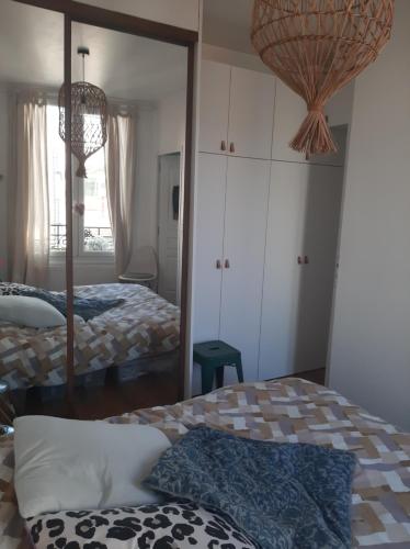 une chambre avec deux lits et un miroir dans l'établissement Cosy appartement, à Fontenay-sous-Bois