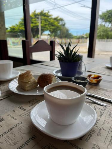 a table with a cup of coffee and bread on it at Hotel Atlantic in Mar de Ajó
