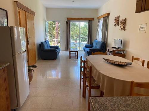 a kitchen and living room with a table and chairs at Kritos Apartments with Two Bedrooms in Argaka