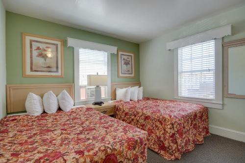 a hotel room with two beds and two windows at Ocean Lodge Hotel South in Ocean City
