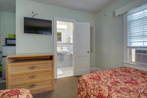 a bedroom with a bed and a dresser with a television at Ocean Lodge Hotel South in Ocean City