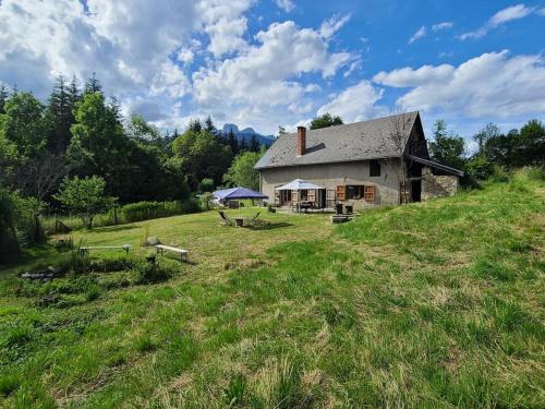 Ein altes Haus auf einem Hügel auf einem Feld in der Unterkunft Calme et plein air in Monestier-de-Clermont