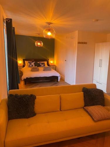 a living room with a couch and a bed at Cozy Cabin with Modern Comforts in Wootton