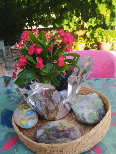 a basket with pink flowers and rocks on a table at Guesthouse Petrino in Pezoúla