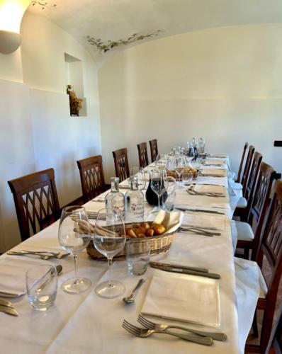 a long table with wine glasses and a basket of fruit at CASCINA DOMINA in Gassino Torinese