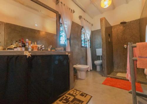 a bathroom with a shower and a toilet and a sink at villa zoe dhahabu BNB in Watamu