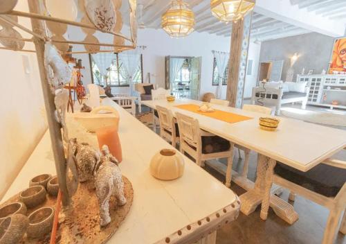 a living room with a table and a dining room at villa zoe dhahabu BNB in Watamu