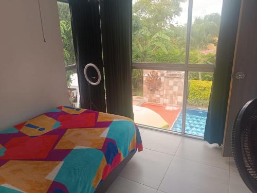 una camera con letto e vista sulla piscina di AKUARELA APARTAMENTOS CAMPESTRES Ibagué a Ibagué