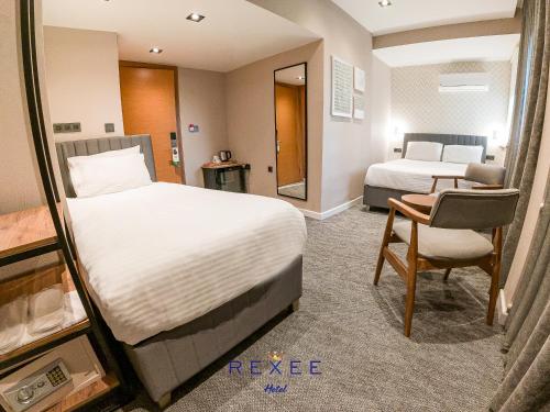 a hotel room with two beds and a chair at Taksim REXXEE Istanbul Istiklal Hotel in Istanbul