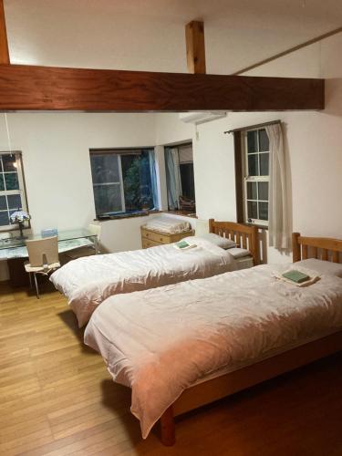 a bedroom with three beds in a room at サンムーン in Kumiage