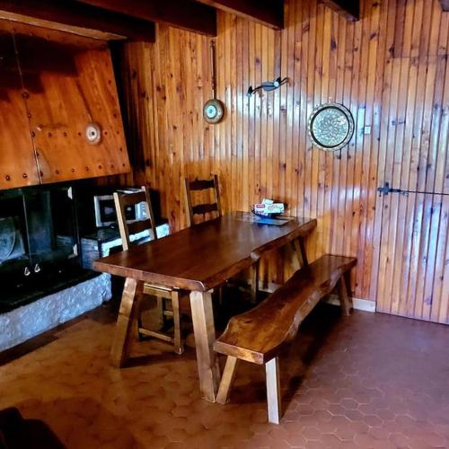 une table en bois et un banc dans une pièce dans l'établissement Maison de campagne, à Usson-en-Forez