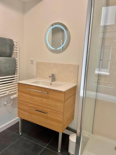 une salle de bain avec un lavabo et un miroir dans l'établissement T2 1er LE VICTOR HUGO, à Cancale