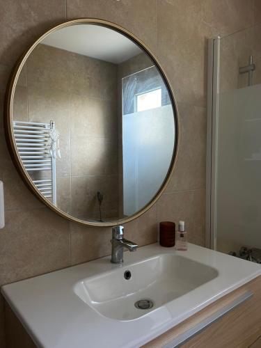 a bathroom with a sink and a mirror at La maison du bonheur in Buchères