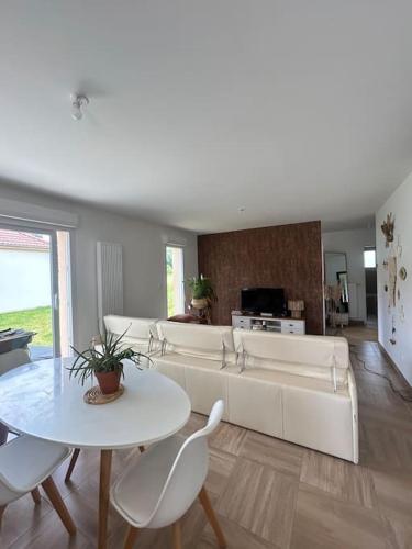 un salon avec un canapé, une table et des chaises dans l'établissement La maison du bonheur, à Buchères