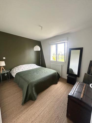 une chambre avec un lit vert et une fenêtre dans l'établissement La maison du bonheur, à Buchères