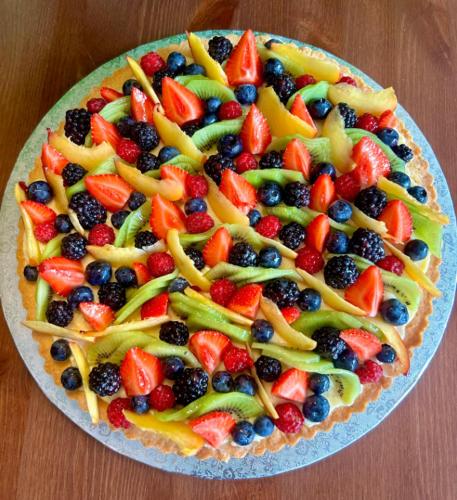 a cake with fruit on a plate on a table at CASCINA DOMINA in Gassino Torinese
