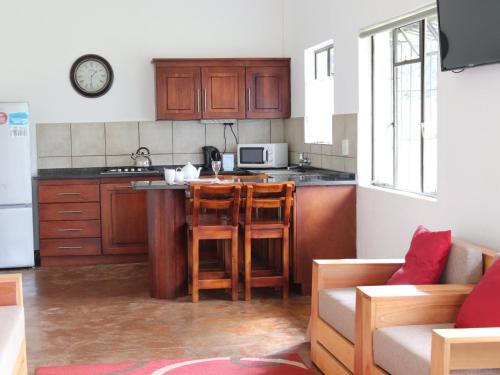 a kitchen with wooden cabinets and a counter top at Levubu Junction Lodge in Louis Trichardt