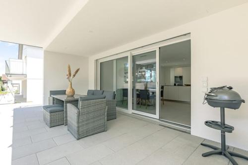 a living room with a table and chairs and a grill at Niesen Apartment - Aare Jungfrau AG in Spiez