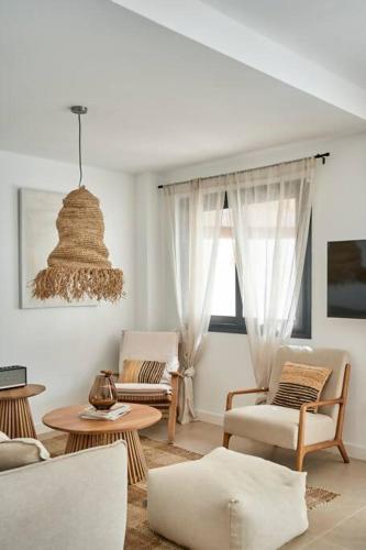 a living room with white furniture and a chandelier at Esencia Marbella Villas Private Pool in Estepona