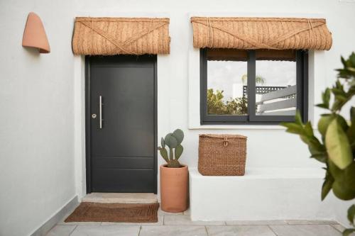a black door with a potted plant next to a window at Esencia Marbella Villas Private Pool in Estepona