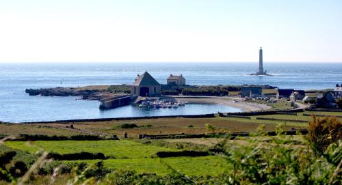 an island in the ocean with a lighthouse in the distance at ibis Cherbourg La Glacerie in Cherbourg en Cotentin