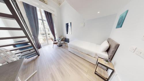 a white living room with a couch and a staircase at MSK Superior in London