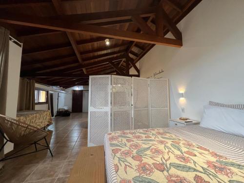 a bedroom with a bed and a chair in a room at Studios Aromas do Campeche - Floripa in Florianópolis