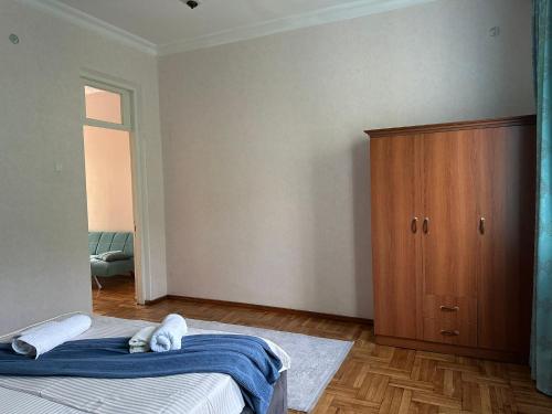 a bedroom with a bed and a wooden cabinet at Horizon Hills - ჰორიზონ ჰილს in Kvariati