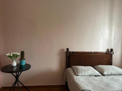 a bedroom with a bed and a table with flowers at Horizon Hills - ჰორიზონ ჰილს in Kvariati