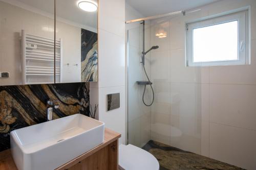a bathroom with a sink and a shower at Domek Letniskowy 4E nad jeziorem nyskim in Skorochow