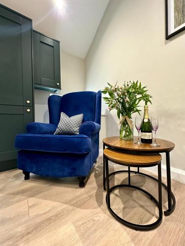 a living room with a blue chair and a table at Dream Catcher One bedroom apartment in Downpatrick