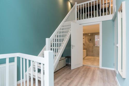 a white staircase in a home with blue walls at 1001 Nights Boutique Lofts in Haarlem
