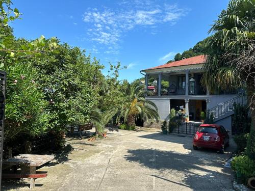 a red car parked in front of a house at Horizon Hills - ჰორიზონ ჰილს in Kvariati