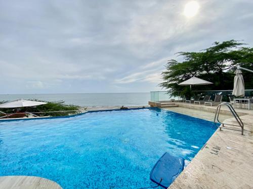 a swimming pool with the ocean in the background at Exclusiva Villa con Salida al Mar in Santa Marta