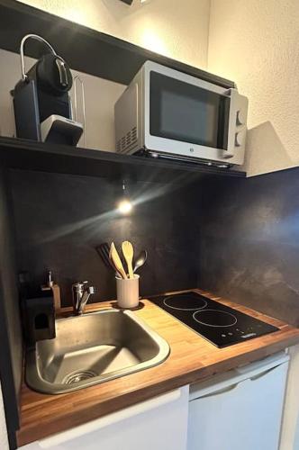 une cuisine avec un évier et un micro-ondes dans l'établissement Nid Douillet, à Lille