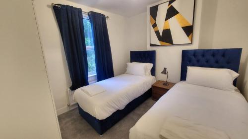 ロンドンにあるGarland Spacious 4 Bedroom House With Garden And Parkingのベッド2台と窓のある寝室