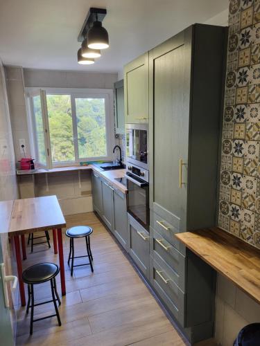 une cuisine avec des armoires vertes, une table et des chaises dans l'établissement Private Room-3 in HANNANA Apartment- 2 min walk To Tram 12 min to Nice train station 15 min to Massena Place, à Nice