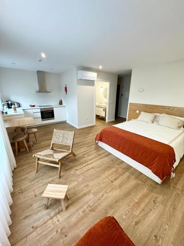 a bedroom with a large bed and a kitchen at Refúgio Verde Douro in Marco de Canaveses