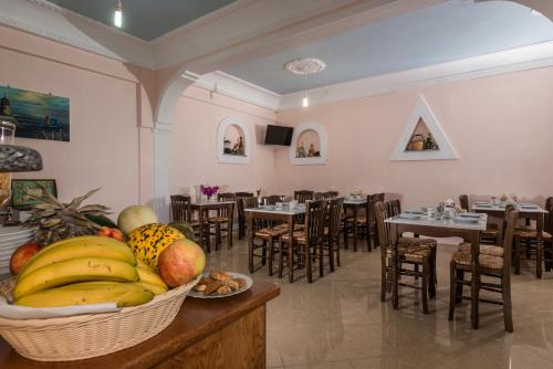 a restaurant with a basket of fruit on a table at Villa Margarita in Karterados