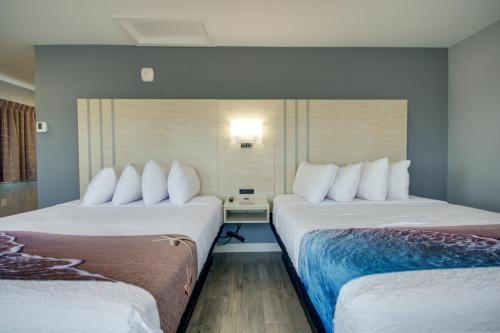 two beds with white pillows in a hotel room at Ocean Lodge Hotel North in Ocean City