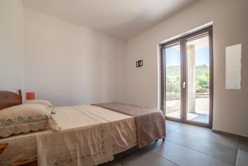 a bedroom with a bed and a large window at Casa Vacanze Signora Cinzia in Torchiara
