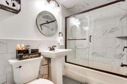 a bathroom with a sink and a clock on the wall at Radiant Arden Home - 10 Mi to Biltmore! in Arden