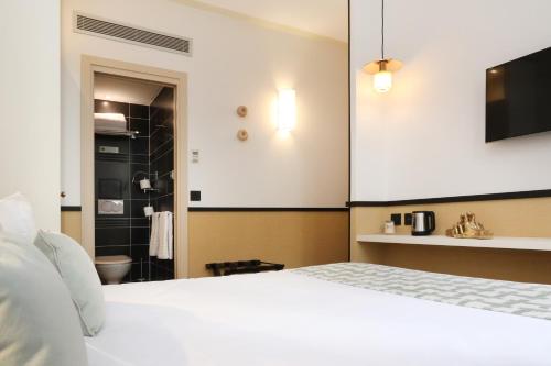 a bedroom with a white bed and a bathroom at Five Boutique Hotel Paris Quartier Latin in Paris