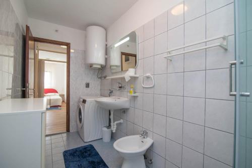 a bathroom with a sink and a toilet and a mirror at Castello in Mali Lošinj