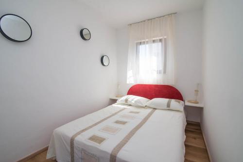 a bedroom with a bed with a red chair at Castello in Mali Lošinj