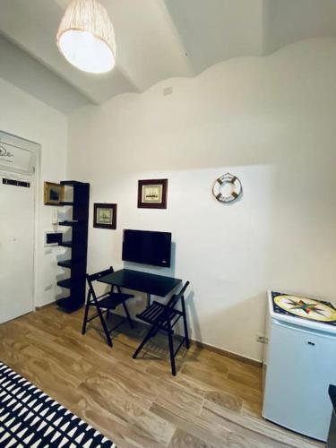 a living room with a table and a stove at Cala del Nostromo - Monolocale in Centro - 50 mt dal Mare in Anzio