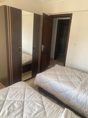 a bedroom with a bed and a mirror at شقق فندقية راقي in Sheikh Zayed