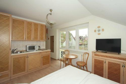 una camera con letto e una cucina con TV di Nadmorskie Pokoje i Apartamenty a Krynica Morska