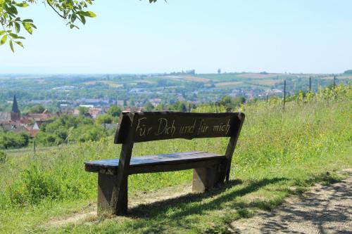 a bench sitting on a hill with a sign that says for god wait for music at Amelie No 3 Hotel & Appartements in Schweigen-Rechtenbach