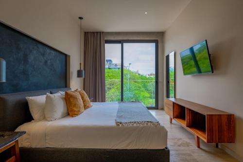 プラヤ・デル・カルメンにあるCeren 203の大きなベッドと大きな窓のある寝室